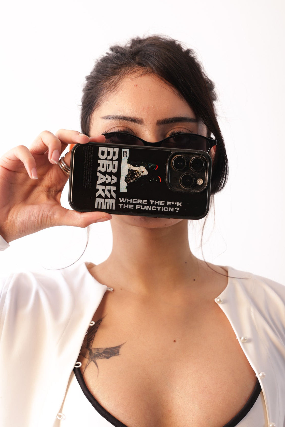 Person holding a phone with a black case featuring white text against a white background